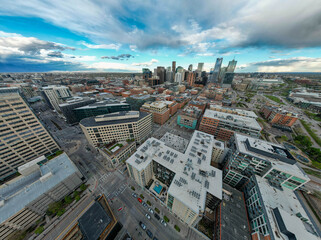 Aerial panoramic view of downtown Denver, Colorado, USA with modern skyscrapers, residential buildings, and green spaces along the river at sunset. Vibrant urban skyline and cityscape architecture.