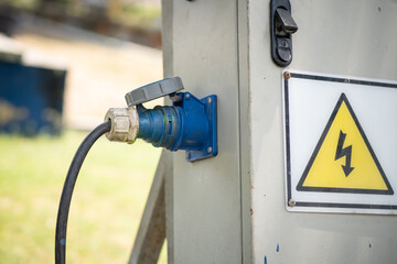 Industrial sockets and plug on outdoor electrical distribution box at Construction site.