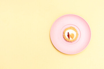 Pandan talam cake on a pink plate on a yellow background