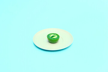 Pandan talam cake on a white plate on a blue background