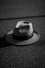 Black and white photograph of a fedora hat placed on the ground, symbolizing mystery, noir style, absence, or a forgotten moment