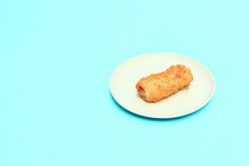 Rissole or risoles on a white plate with a blue background