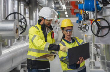 Team Coordinates HVAC System Check Two industry professionals working in coordination to inspect and verify the function of the complex air control system