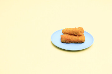 Rissole or risoles on a blue plate with a yellow background