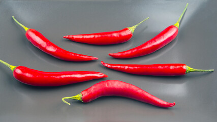 Fresh red chili peppers arranged on a dark surface showcasing their vibrant colors and shapes