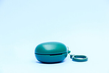 A pair of green True Wireless Stereo (TWS) earbuds, displayed against a blue background. The earbuds are clearly visible, showcasing their sleek design and compact size, with the green color standing 