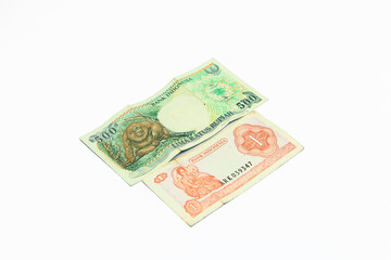 Old five hundred rupiah note with a picture of a monkey and one rupiah note with a picture of General Sudirman on a white background