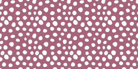 Aesthetic pattern of white dots of different sizes on dusty pink background. 