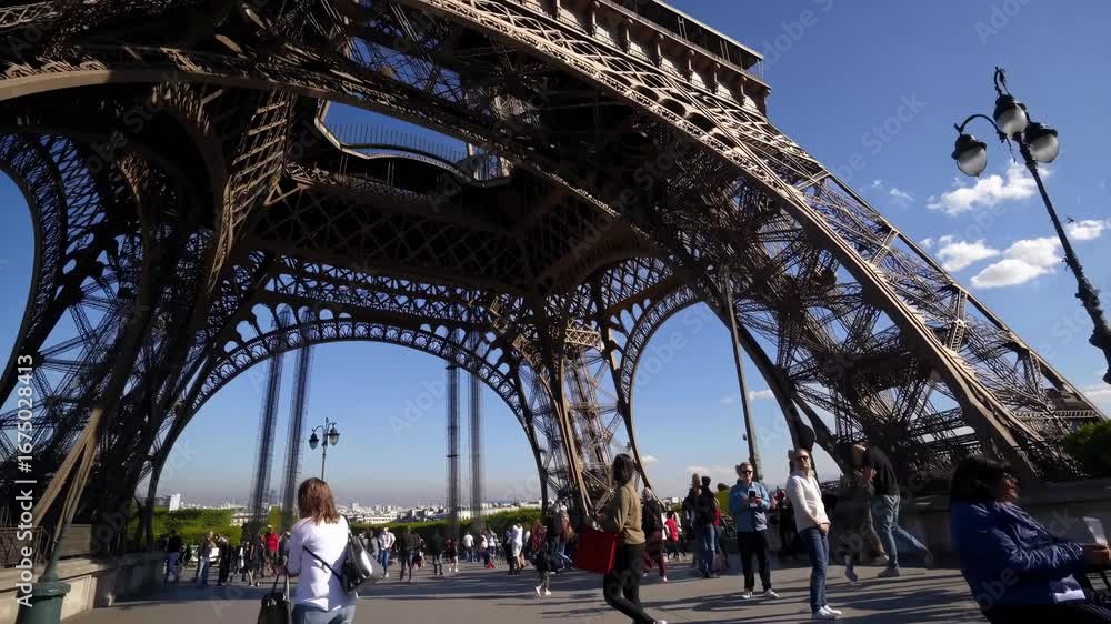 Poster dynamic low-angle shot of the eiffel tower against a bright sky, capturing the iconic structure and 