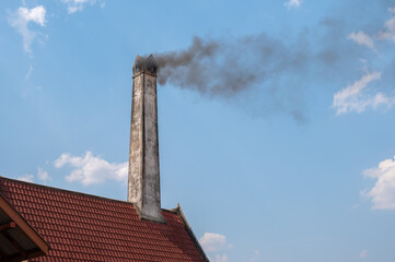 Fototapeta premium Smoke from a crematorium chimney. Crematory or cremation center is a venue for the cremation of the dead.