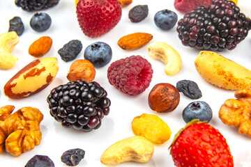 Colorful assortment of nuts and berries arranged artistically on a white surface