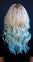 Naklejka premium Close-up of a woman from behind with shoulder-length blonde hair, half dyed in ombre green to white and the other half in long pastel blue waves