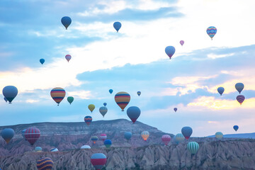 Hot air balloons fill the sky over Cappadocia, Turkey during sunrise
