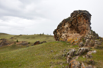 Unique rock formations rise above the grassy terrain.