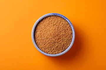 Indian spice of food called yellow mustard isolated on orange background 