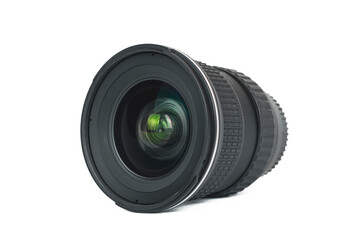 A professional camera lens viewed from the front, isolated on a clean white background. The intricate glass elements of the lens reflect ambient light with a subtle green and yellow flare.
