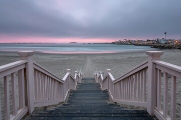 Obraz premium Pink Wooden Beach Stairs Leading To The Ocean At Sunset