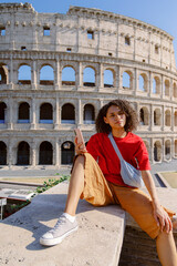A young person takes a moment to relax near the iconic Colosseum in Rome, savoring the vibrant atmosphere and admiring the stunning historical architecture of this magnificent ancient city