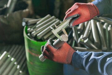 Worker in Red Gloves Measuring Steel Pipe with Caliper Industrial Toolset: Close Up of Hands...