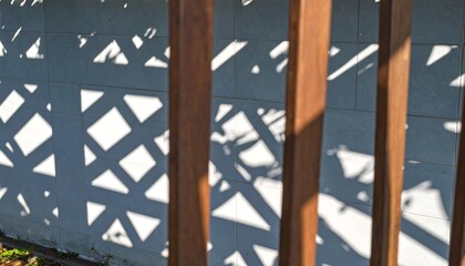 Obraz premium Shadows through pergola on light gray wall