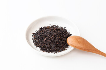 皿の上の紅茶葉とスプーン　白バック
