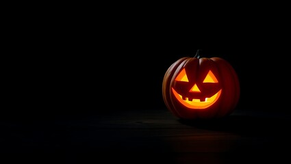 Illuminated jack o lantern with a smiling face on a dark background casting a soft orange glow around it
