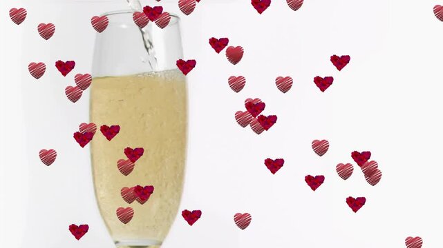Pouring champagne filling flute bubbling drifting red hearts swirling around glass adding romance