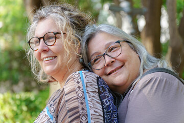 Happy mature lesbian couple enjoying a tender moment together in nature, celebrating their love and lgbtq pride