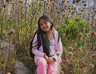Smiling elementary school student hiking in wildflower field
