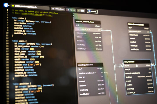 Close-up view of SQL database schema design and code editor on a computer screen, illustrating data structure planning and software development workflow for modern web applications.