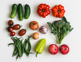 Creative food background of fresh vegetables and fruits on a light background, top view