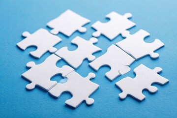 White jigsaw puzzle pieces on a light blue surface