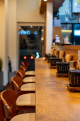 Counterbar seating inside the restaurant with gyukatsu grill tabletop. It is a small portable ceramic or volcanic stone grill.