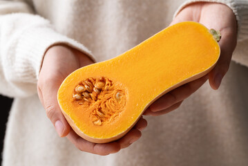 Half butternut squash pumpkin holding by woman hand