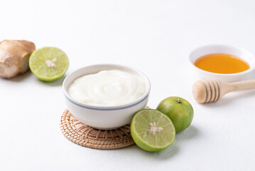 Yogurt, lime, honey and ginger on white background