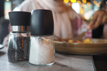 Salt and pepper shakers on a dining table at a restaurant