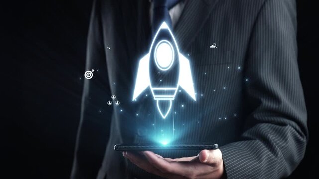 A businessman in a formal suit holds a smartphone displaying a vibrant rocket icon and various digital symbols, symbolizing innovation, growth, and the startup journey. Qubit