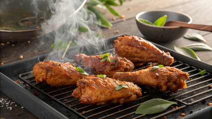 Delicious and smoky grilled chicken wings with fresh herbs on a rustic wooden surface for food lovers