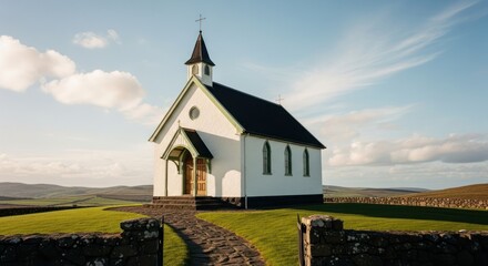 Fototapeta premium Small white church sits on a hill with clouds in the sky