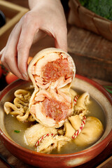 Traditional Inner Mongolia lamb belly wrapped in intestine casing being added to dumpling soup
