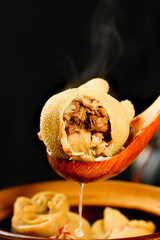 Traditional Mongolian pork dumplings served with wooden ladle - steaming hot homemade Asian cuisine