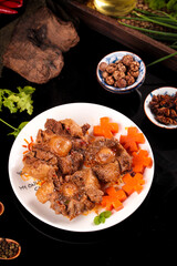 Spicy Braised Oxtail Stew with Carrots and Traditional Chinese Spices on Dark Wooden Background
