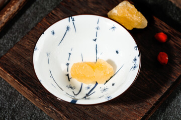 Yellow Rock Sugar Candy in Traditional Ceramic Bowl on Wooden Tray for Asian Tea Ceremony