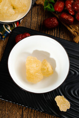 Yellow Rock Sugar Cubes in Bowl with Dates and Tea on Wooden Table - Traditional Handmade Candy Sweetener
