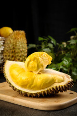 Fresh Golden Durian Fruit Cut Open Showing Creamy Yellow Flesh on Wooden Board