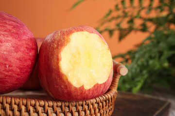 Fresh Red Fuji Apple with Bite Taken Out in Wicker Basket Display