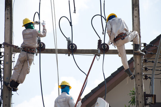 An electrician installing equipment on the electric pole