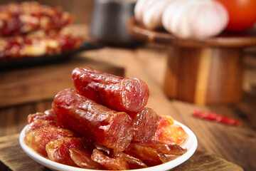 Air-dried salami and cured meat sausages on rustic wooden background - gourmet delicatessen food...