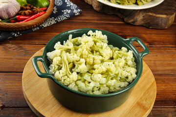 Dried Sichuan Cauliflower Display - Crispy Chinese Vegetable Dish in Green Bowl on Wooden Background