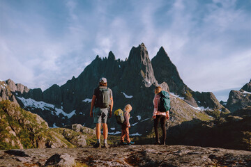 Family backpackers climbing mountains in Norway - dad, mom and child hiking in Lofoten islands active healthy lifestyle tour adventure hobby summer vacations trip outdoor, parents and kid together